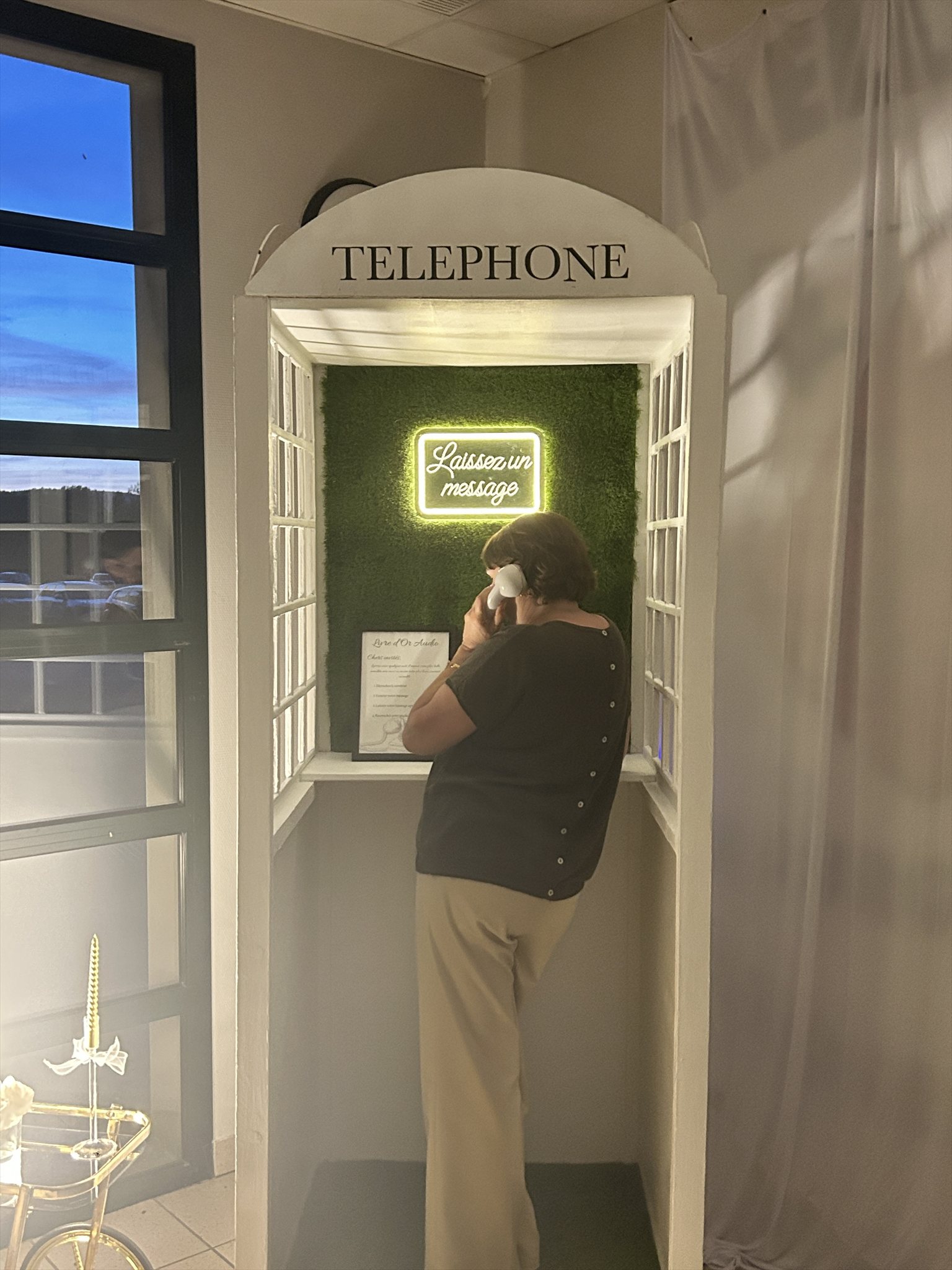Invitée laissant un message vocal dans la cabine téléphonique vintage lors d'un mariage à Buxy